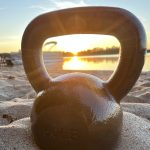 kettlebell on the beach during a sunrise