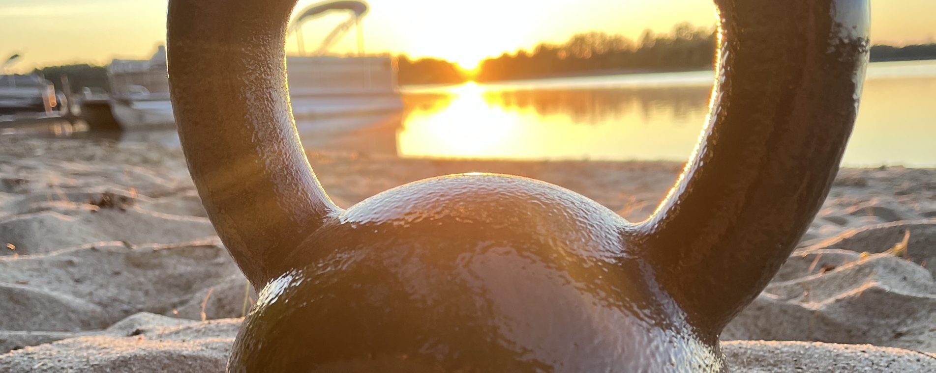 kettlebell on the beach during a sunrise
