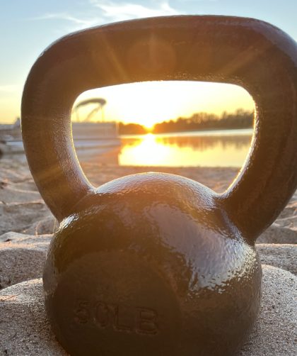 kettlebell on the beach during a sunrise