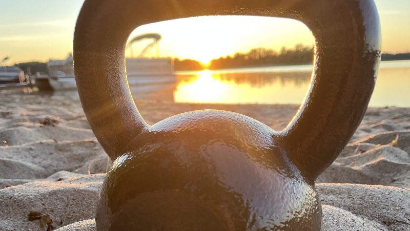 kettlebell on the beach during a sunrise