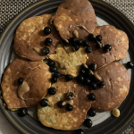 plate of coconut flour pancakes with almond butter and blueberries