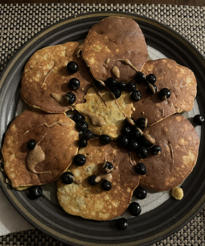 plate of coconut flour pancakes with almond butter and blueberries