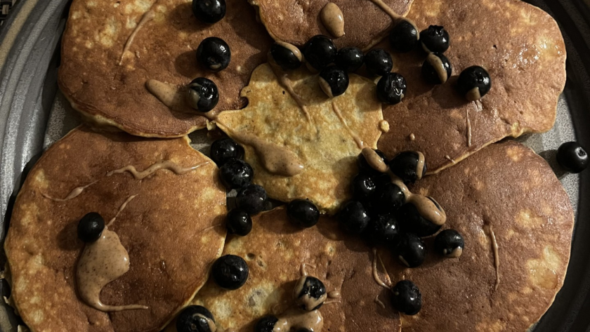 plate of coconut flour pancakes with almond butter and blueberries