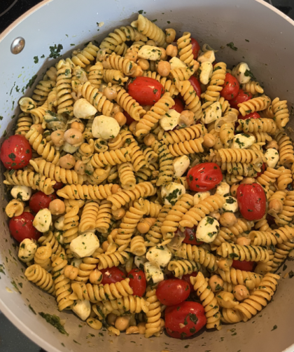 A pot of pasta, beans, tomatoes, mozzerella, basil, and a vinaigrette dressing
