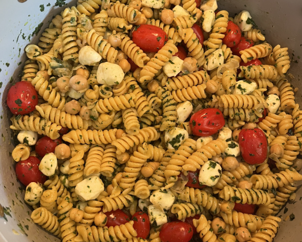 A pot of pasta, beans, tomatoes, mozzerella, basil, and a vinaigrette dressing