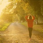 person walking on a road in the sun