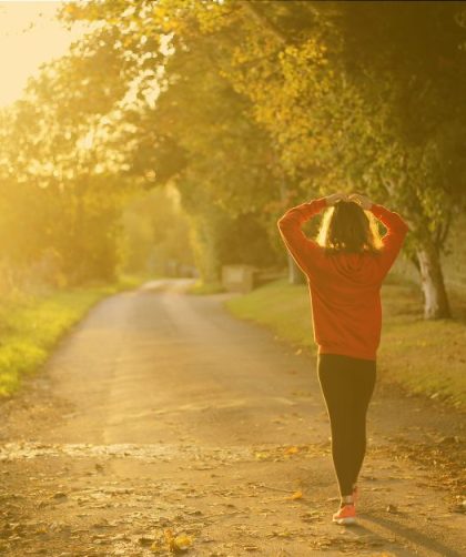 person walking on a road in the sun
